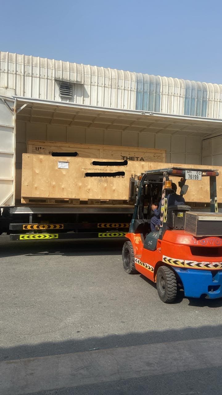 A crated shipment being loaded onto a truck by forklift